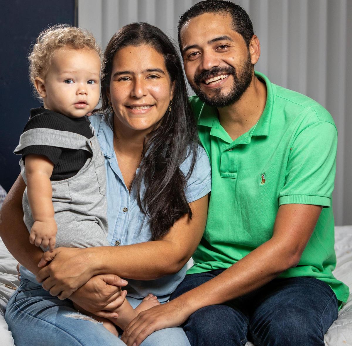 Kimberly Lanz, center and her husband Edirson Azocar, right with their 1-year-old baby Jake Azocar, left, in their home in Miami.
