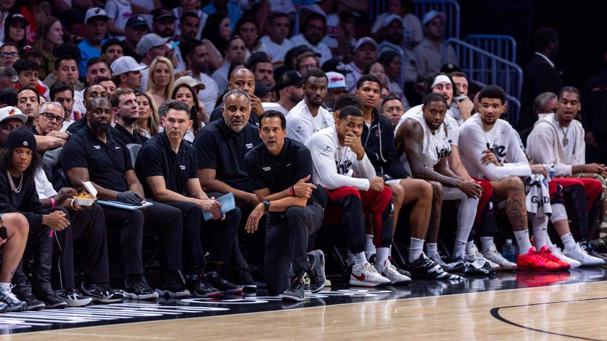 Miami Heat players and coaches watch a play from the sideline during the second half of Game 4 of the first round of the NBA playoffs against the Cleveland Cavaliers at Kaseya Center on April 28, 2025, in Miami.