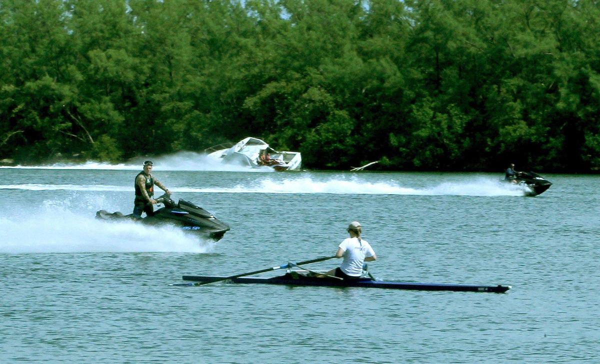 A Miami Rowing Club rower slows down to avoid the wake of water bikes at the Miami Marine Stadium lagoon on Virginia Key, where motorized boat traffic has surged during the coronavirus pandemic, creating a conflict with rowers and paddlers.