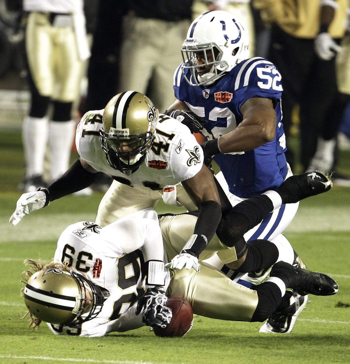 New Orleans Saints safety Chris Reis (39) recovers an on-side kick as Indianapolis Colts Cody Glenn (52) hits Roman Harper (41) from behind during the second half of the NFL Super Bowl XLIV football game in Miami, Sunday, Feb. 7, 2010. (AP Photo/Lynne Sladky) ORG XMIT: SB322