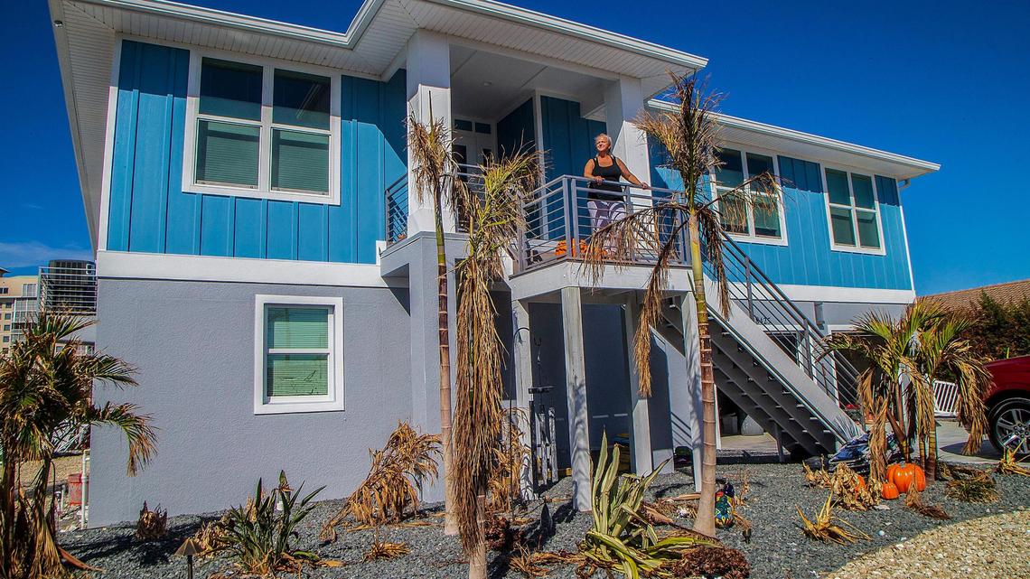 Amy Rizzo stands by the entrance of her Lagoon Road stilted house Wednesday, Oct. 26, 2022. She and her husband stayed in the house when Hurricane Ian made landfall in the area Wednesday, Sept. 28, 2022.