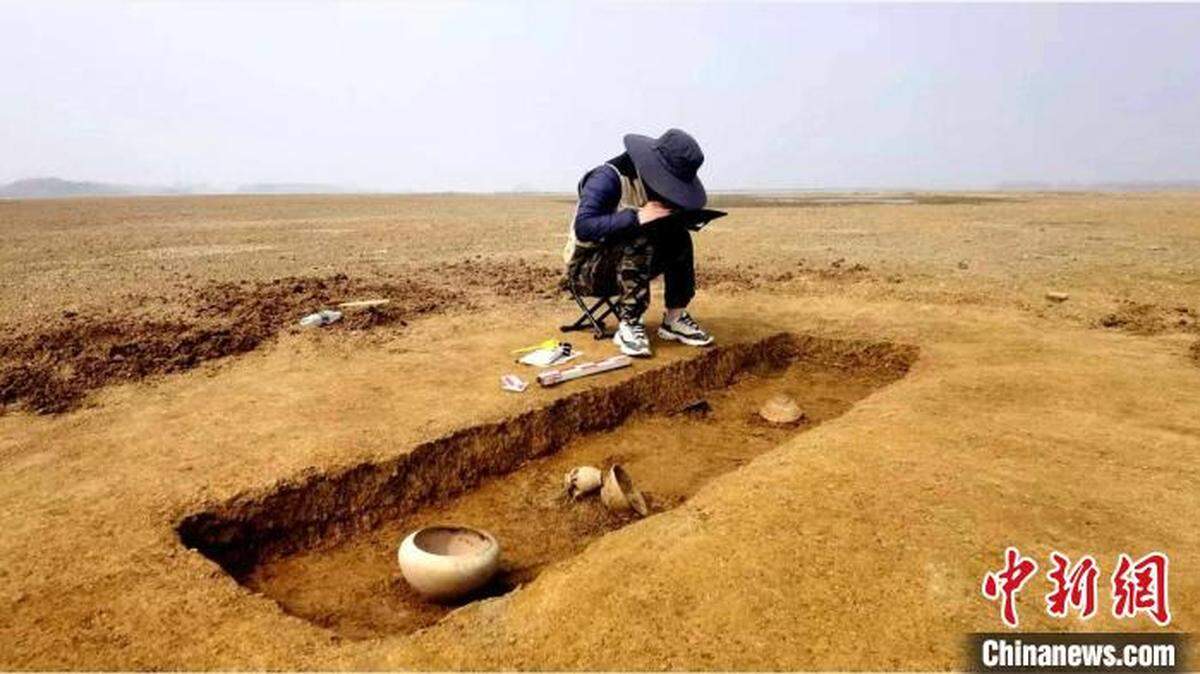 Archaeologists on an island in Hunan found a 12,000-year-old burial site with treasures after the beach was exposed by drought, photos show.