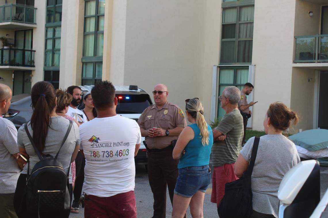 A Miami-Dade Sheriff’s Office deputy speaks to residents of the International Park apartments, informing them of the work authorities did to remove a barricaded man from his apartment after he allegedly hurt two of his children and slammed his 5-year-old son against a wall on June 7, 2025.