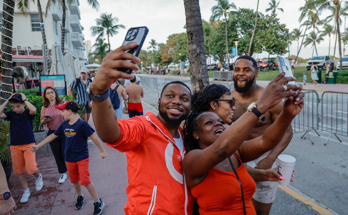 Spring breakers, who would only give their first name, Mario, Jessie, Tamika and EJ, left to right, take a selfie on their smart phones on Ocean Drive during spring break in Miami Beach, Florida on Friday, March 8, 2024.