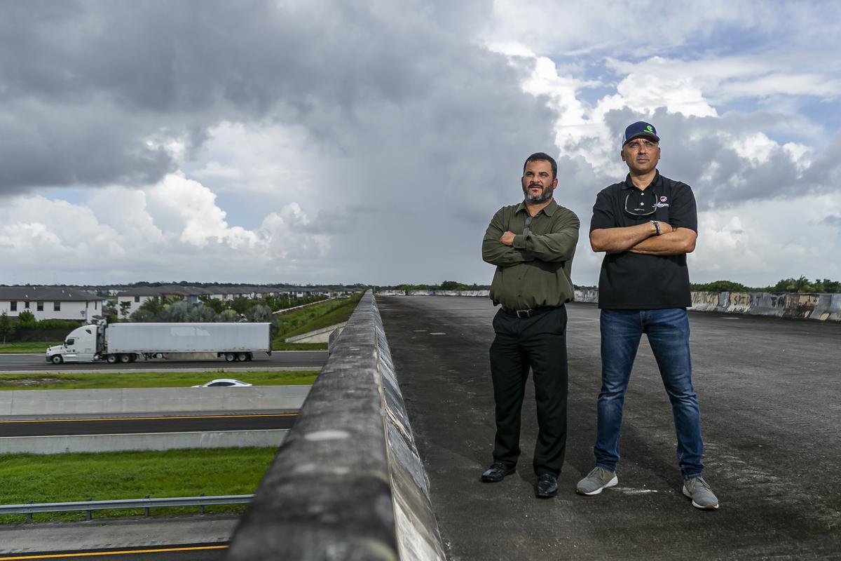 Eduardo Lavin, 43, left, and Eddie Santiesteban, 43, stand on Northwest 154th Street in Hialeah where a closed bridge would connect their neighborhood to Miami Lakes. Lavin and Santiesteban are asking Miami-Dade County officials to open the bridge so that their neighborhood would have a second outlet for traffic and emergency vehicles.