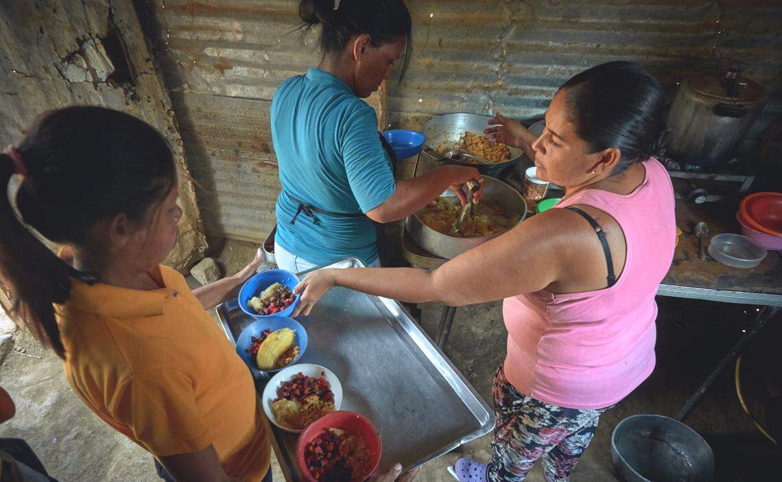 Varias madres cocinan para sus hijos en un programa comunitario para niños desnutridos en Venezuela.