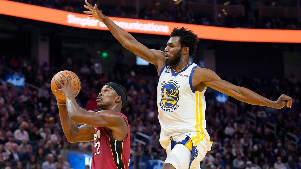 El delantero del Miami Heat, Jimmy Butler, a la izquierda, dispara contra el delantero de los Golden State Warriors, Andrew Wiggins, durante la primera mitad de un partido de baloncesto de la NBA en San Francisco, el jueves 27 de octubre de 2022.