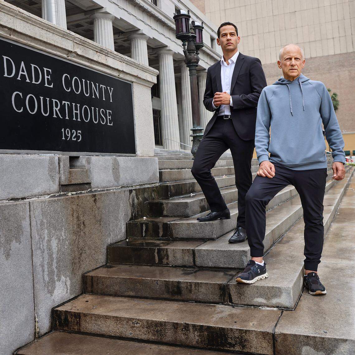 Pablo Langesfeld, left, who lost his daughter and son-in-law in the 2021 Champlain Towers collapse, stands with his son Martin, right, outside the old Dade County Courthouse in Miami, Tuesday, April 7, 2026. Langesfeld, now battling advanced pancreatic cancer, is suing Oscar Health Insurance for denying coverage of a drug therapy his doctors recommend, underscoring broader struggles over access to treatment.