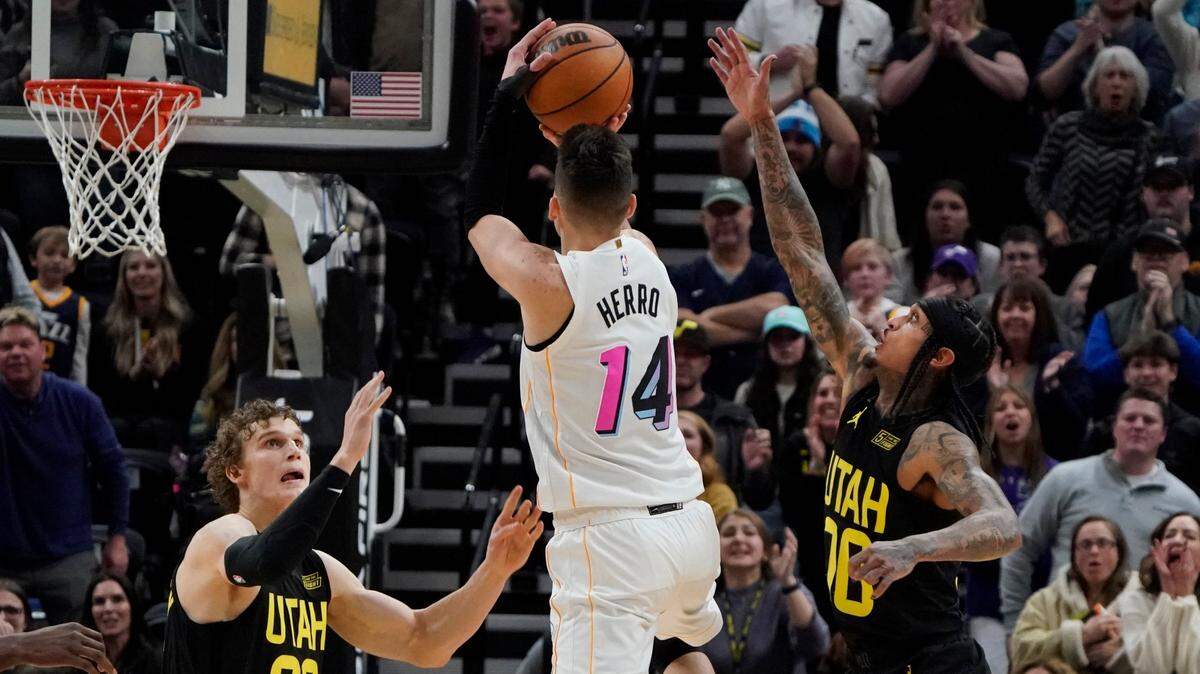 Miami Heat guard Tyler Herro (14) hits the game-winning shot as time expires, while Utah Jazz forward Lauri Markkanen (23) and guard Jordan Clarkson (00) defend during the second half of an NBA basketball game Saturday, Dec. 31, 2022, in Salt Lake City.
