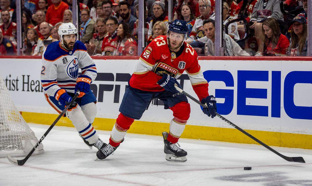 Sunrise, Florida, June 8, 2024 - Florida Panthers center Carter Verhaeghe (23), right, looks to make a pass as Edmonton Oilers defenseman Evan Bouchard (2), left defends during game 1 of the Stanley Cup Final at Amerant Arena in Sunrise, Florida.