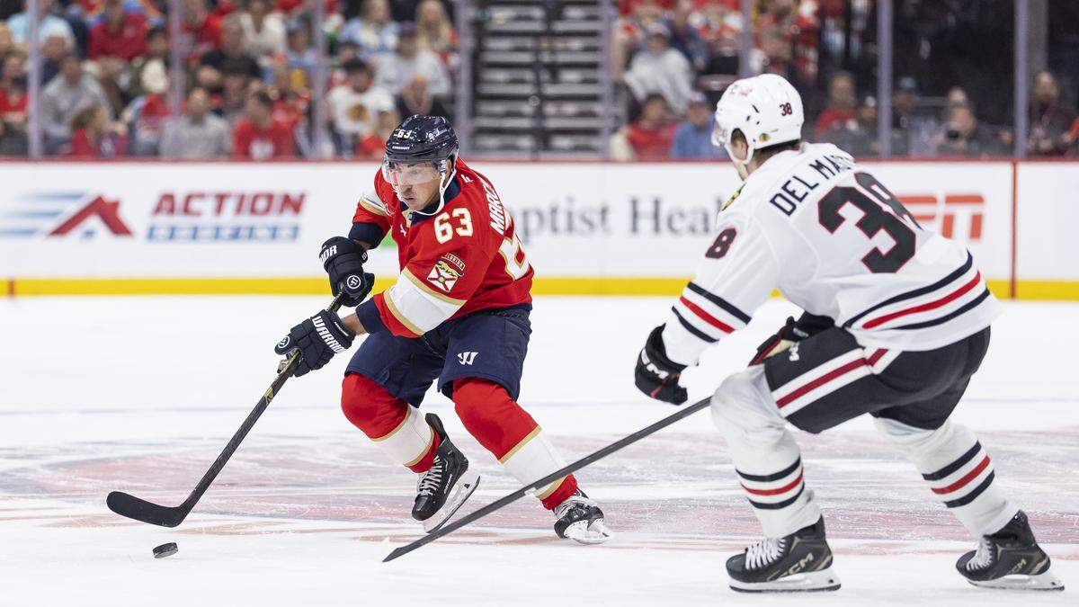 Florida Panthers left wing Brad Marchand (63) skates with the puck as Chicago Blackhawks defenseman Ethan del Mastro (38) defends in the second period of their NHL game at Amerant Bank Arena on Tuesday, Oct. 7, 2025, in Sunrise, Fla.