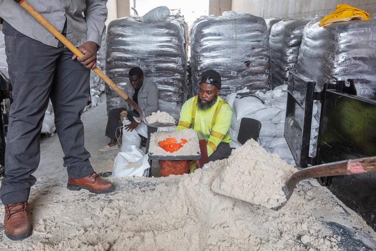 (L) Mel Víctor, (C) Frito Charmant and (R) Wilbert Avril make sandbags ehen The City of North Miami Beach gives out sandbags to residents ahead of the expected flooding in the next few days in 1965 NE 151st Street, North Miami Beach on Saturday October 5ve., 2024.