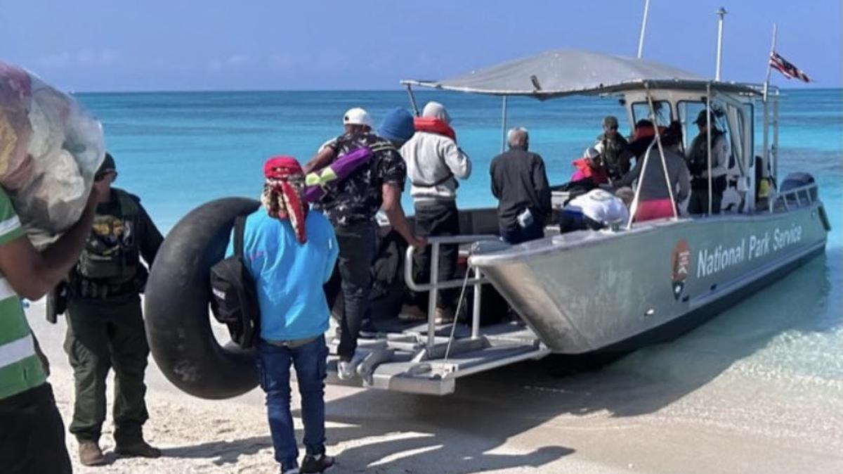 People walk onto a National Park Service boat in the Dry Tortugas Thursday, Feb. 23, 2023, after arriving on a migrant vessel from Cuba, according to the U.S. Border Patrol.