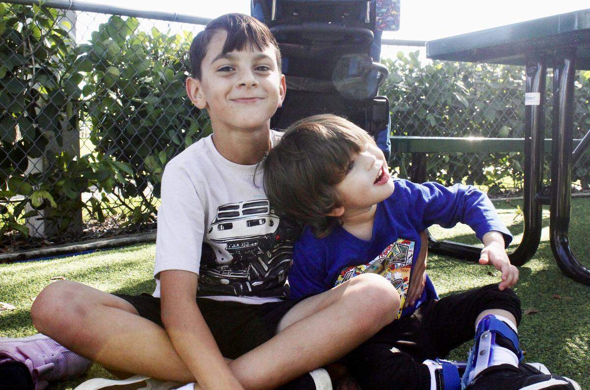 Nine-year-old Matthias Rodriguez (left) puts his arm around his brother Mason at Cypress Park playground in Coral Springs. 