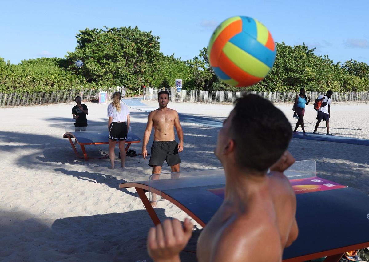 Luka Vidos, right, hits a volleyball on his head while Petar Grgasovic, from Miami, waits to return the ball while they play table volleyball during spring break on Sunday, March 26, 2023, in South Beach.