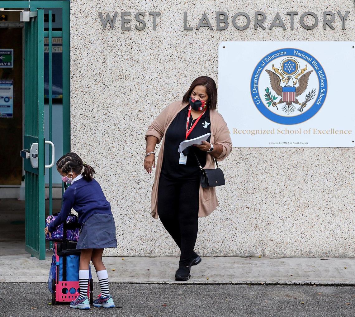 A student gathers her things as she prepares to enter West Lab. Parents drop off their children at Henry S. Laboratory School, where more than a majority of parents elected to send their children to school as members of the staff greet them on Monday, October 5, 2020.