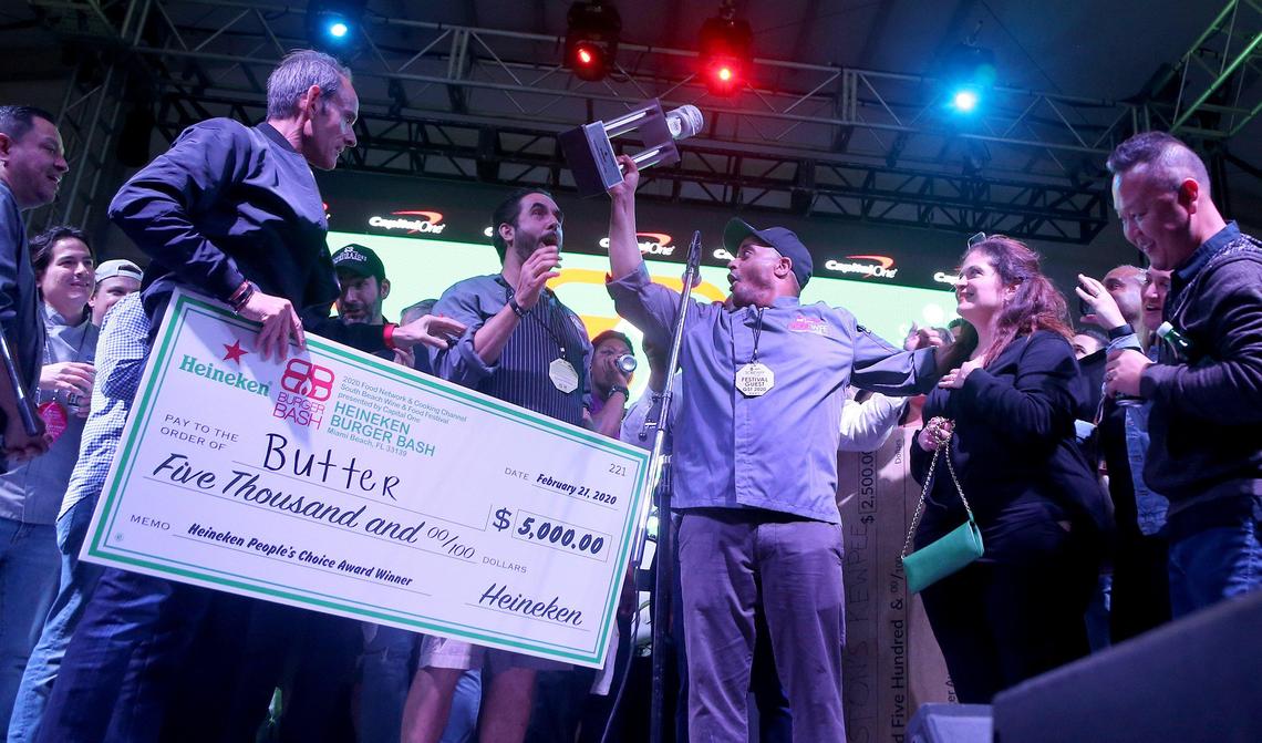 Chefs Alex Guarnaschelli (second from right) and Michael Jenkins (holding the trophy) react as New York City’s Butter, received the People’s ‘ choice award at the 2020 South Beach Wine & Food Festival’s Burger Bash.