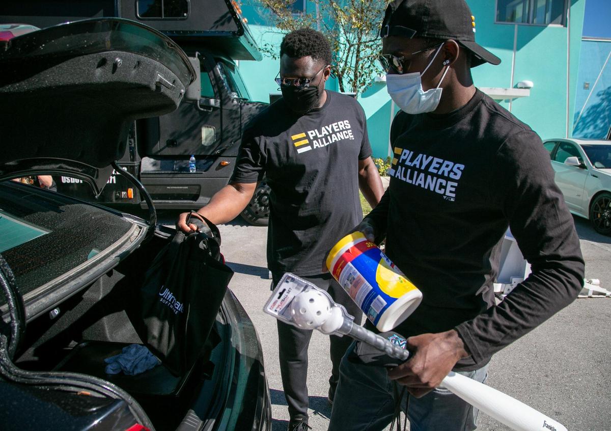 Miami, Florida, January 5, 2021- Former Marlins great Charles Johnson (center) and current Marlins playerJazz Chisholm (right) load up a vehicle with baseball items as well as disinfectant wipes and food at Gibson Park in Overtown during a visit by the Players Alliance while on their Pull Up Neighbor Tour. On December 1, 2020, The Players Alliance Launched a two month, cross-country mobile tour in partnership with Pull Up Neighbor, a Black-owned community response team. Many underserved children have endured countless losses due to the pandemic, including access to learn and play baseball. This programÕs goal is to help counter all that and provide support during these uncertain times. The Players Alliance, a nonprofit organization comprised of more than 150 active and former Major League Baseball players, was at Overtown’s Gibson Park from 1 p.m.-3 p.m. on Tuesday, January 5, 2021, as part of its Pull Up Neighbor tour. The group, led by one-time Marlin Curtis Granderson, has already stopped at 15 other cities throughout the country.