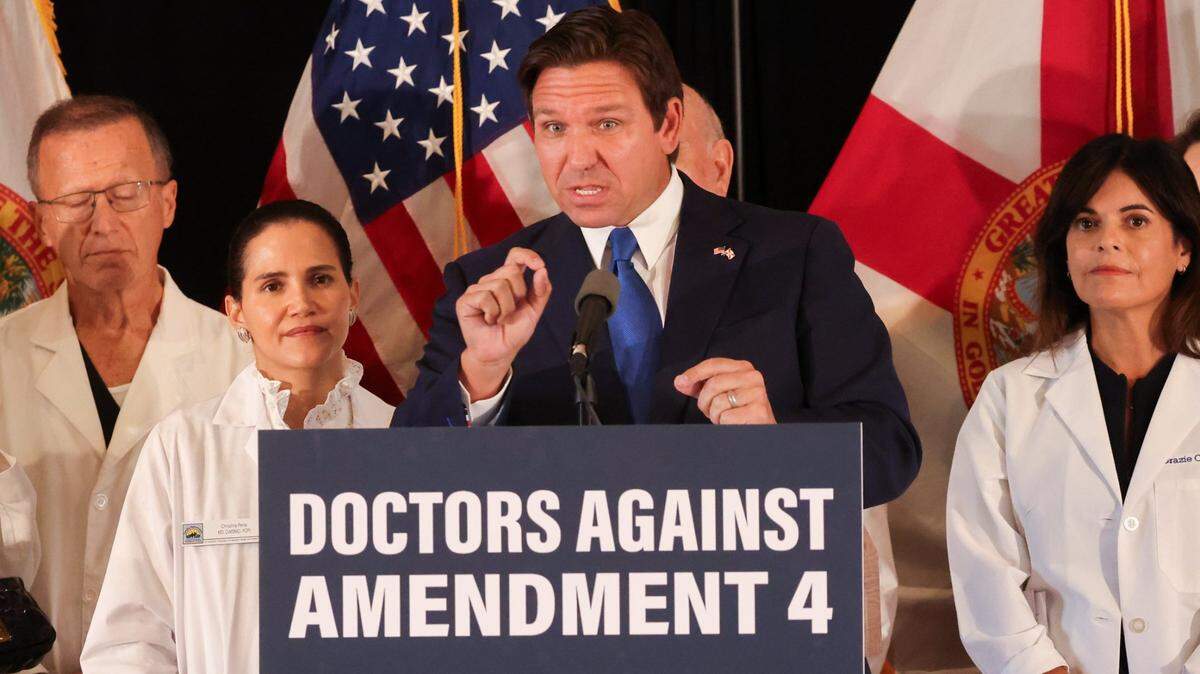 Florida Governor Ron DeSantis comments on his opposition to Amendment 4 as several doctors stand behind him during his press conference at Comber Hall on Monday, October 21, 2024, the first day of early voting in Coral Gables, Florida.