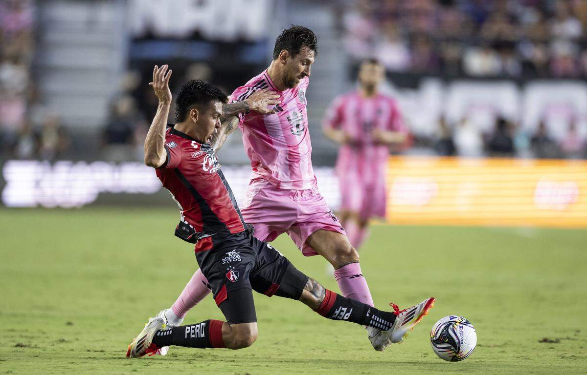 Inter Miami forward Lionel Messi (10) and Atlas defender Jorge Rodríguez (25) compete for the ball in the first half of their Leagues Cup Phase One soccer match at Chase Stadium on Wednesday, July 30, 2025, in Fort Lauderdale, Fla.
