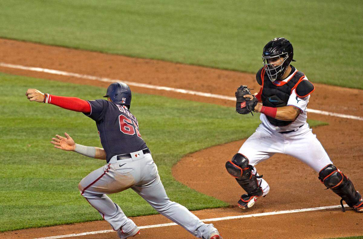 Miami Marlins catcher Jorge Alfaro (38) chase down Washington Nationals second baseman Luis García (62) during the seventh inning of the first game of a baseball doubleheader at Marlins Park in Miami on Sunday, September 20, 2020.
