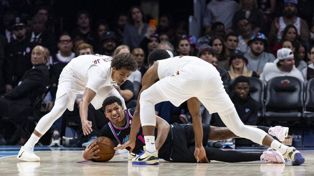 Miami Heat guard Dru Smith (12) fights for a loose ball against Cleveland Cavaliers guard Craig Porter Jr. (9) and forward De'Andre Hunter (12) in the second half of their NBA game at the Kaseya Center on Wednesday, Nov. 12, 2025, in downtown Miami, Fla.