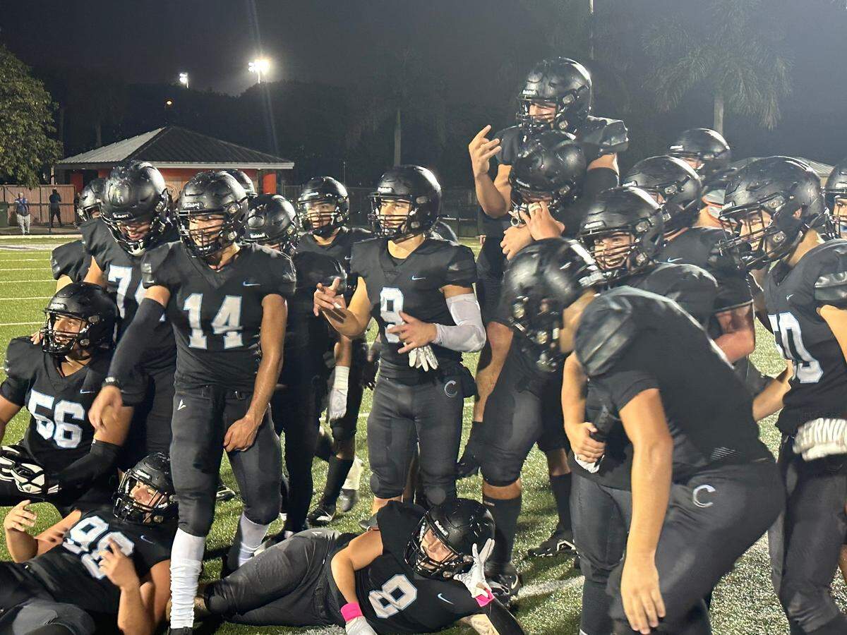 Archbishop Carroll’s football players celebrate after defeating Ransom Everglades 35-13 on Friday night at Harris Field Park in Homestead.