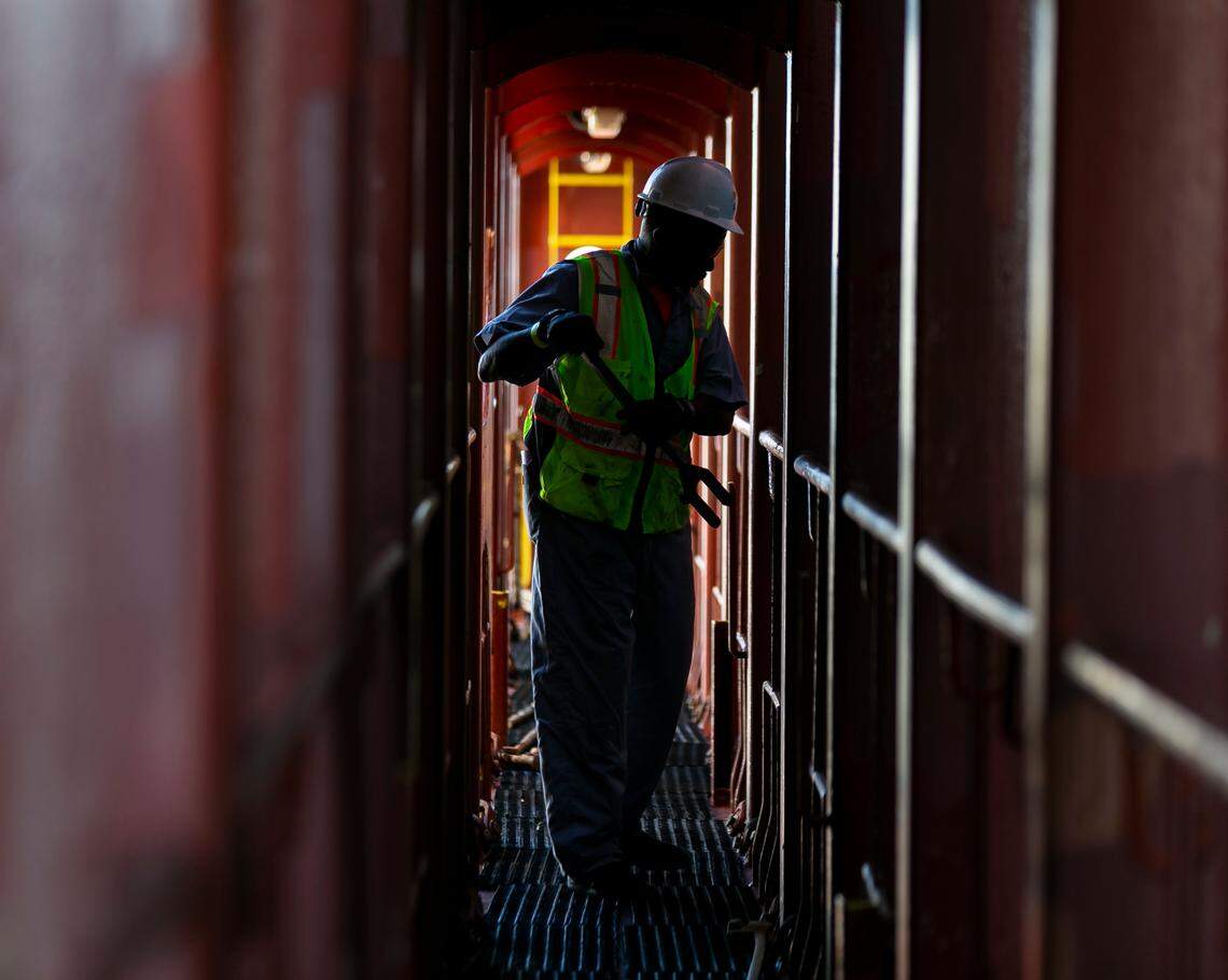 Longshoreman Michael Daniels works to unhook containers inside a docked cargo ship at PortMiami on Saturday, February 20, 2021. Daniels, a lasher, has been working as a longshoreman for 40 years.