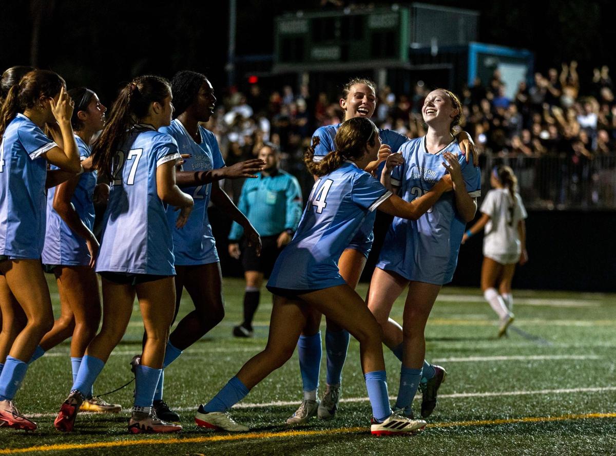 Ransom Everglades teammates swarm attacker Charlie Jaffee (25) after she scored the finalizer against Palmer Trinity to win 4-3 during the girls soccer 4-2A Regional Final on Wednesday, February 19, 2025, in Coconut Grove, Florida.