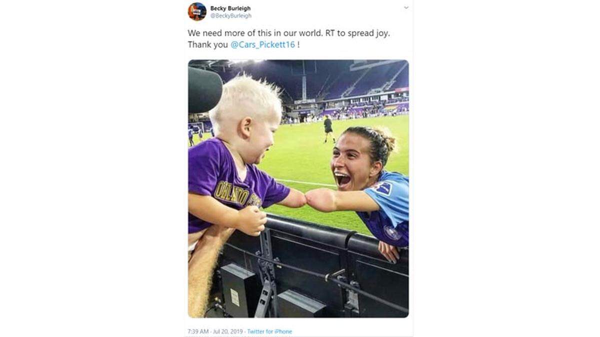 Orlando Pride player Carson Pickett (right) dabs fan Joseph Tidd at a recent game. The photo has gone viral on Twitter.