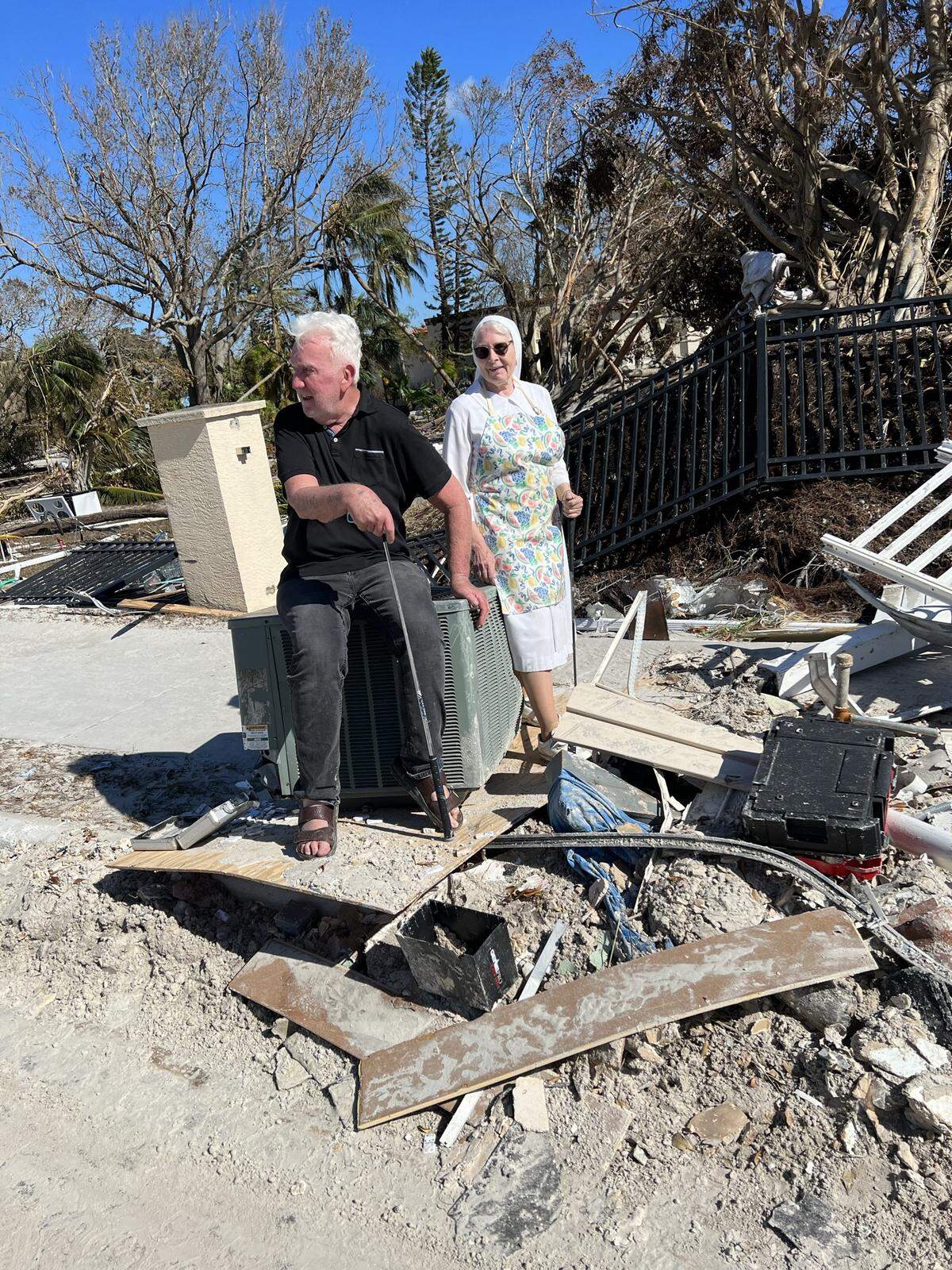 Debris surrounds Father William Adams and Poor Clare Abbess, Sister Mary Frances of Jesus Fortin, as they are seen on the property of Ascension Parish and San Damiano Monastery on Fort Myers Beach on Oct. 1, 2022, destroyed by the storm surge of Hurricane Ian.