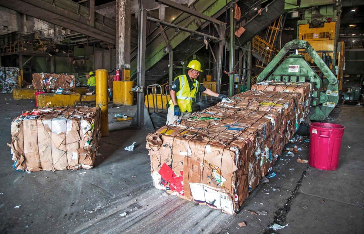 Carmelo Andino, operations supervisor, inspects a recycled cardboard bale ready for shipping at the Waste Management regional recycling plant at 20701 Pembroke Road in Pembroke Pines on Friday, April 8, 2022.