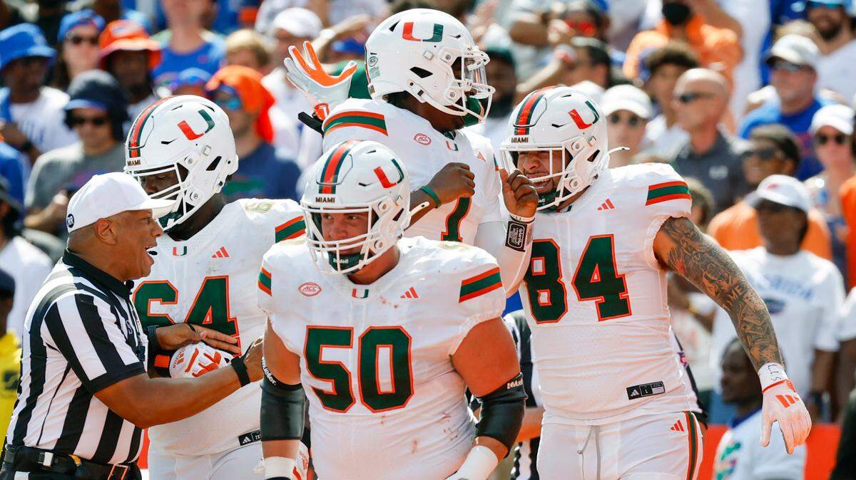 Miami Hurricanes tight end Cam McCormick (84) celebrates with teammate Cam Ward (1) after scoring a touchdown during the first half of an NCAA college football game against the Florida Gators at Ben Hill Griffin Stadium in Gainesville, Florida, on Saturday, August 31, 2024. 