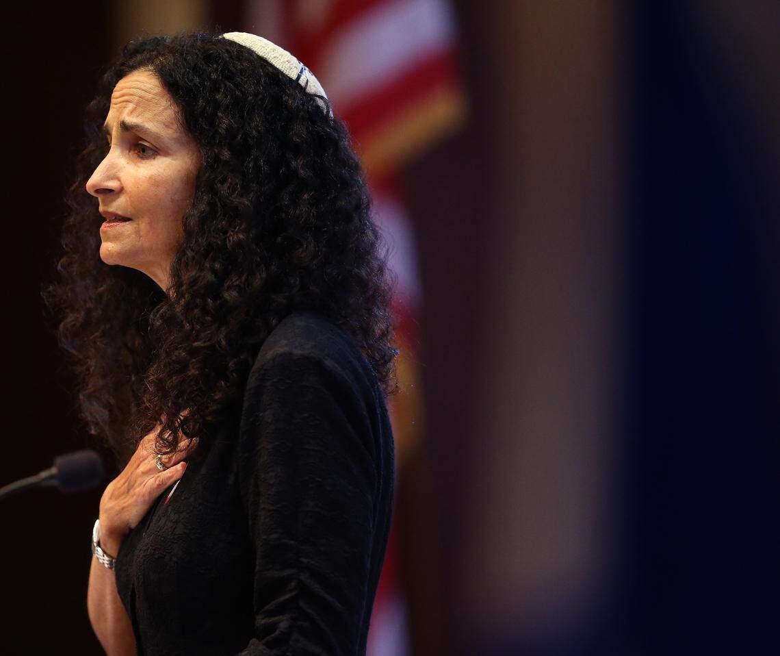 Rabbi Gayle Pomerantz places her hand on her heart as she and members of the Beth Sholom synagogue in Miami Beach gathered on Sunday, Oct. 28, 2018, for “A Time to Grieve,” a service to remember victims of the mass shooting at a Pittsburgh temple.