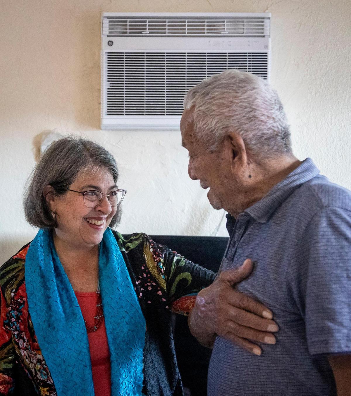 La alcaldesa del Condado Miami-Dade, Daniella Levine Cava, a la izquierda, habla con Julio Banegas, de 86 años, en el interior de su apartamento, frente a una de las tres unidades de aire acondicionado instaladas recientemente en su apartamento. La alcaldesa Daniella Levine Cava y otros funcionarios anunciaron una iniciativa para financiar nuevas unidades de aire acondicionado para cientos de apartamentos de viviendas públicas durante una conferencia de prensa el lunes 28 de noviembre en 2846 NW 10th Avenue, Miami, Florida.