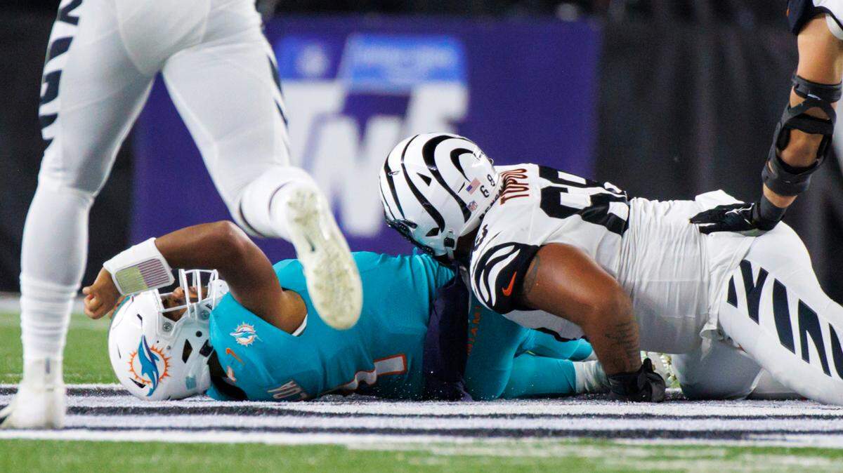 Miami Dolphins quarterback Tua Tagovailoa (1) laid down on the field after being sacked by Cincinnati Bengals defensive tackle Josh Tupou (68) during the second quarter of an NFL football game at Paycor Stadium on Thursday, September 29, 2022 in Cincinnati, Ohio.
