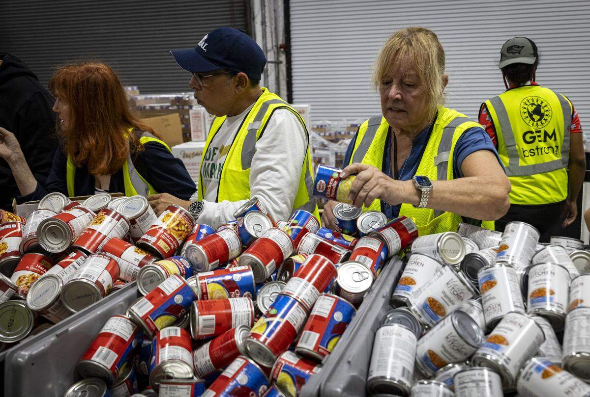 Volunteer Terry Springer, right, prepare care packages for Jamaica at Global Empowerment Mission in Doral. The donations will head to the island after Hurricane Melissa passes.