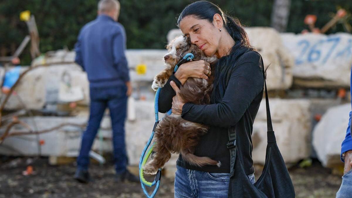 Flavia Paparella embraces her friends dog Raul, while attending a Moment of Reflection ceremony marking the transition into the next phase of the Champlain Towers South Memorial project at Veterans Park, in Surfside, Florida on Wednesday, February 4, 2026.