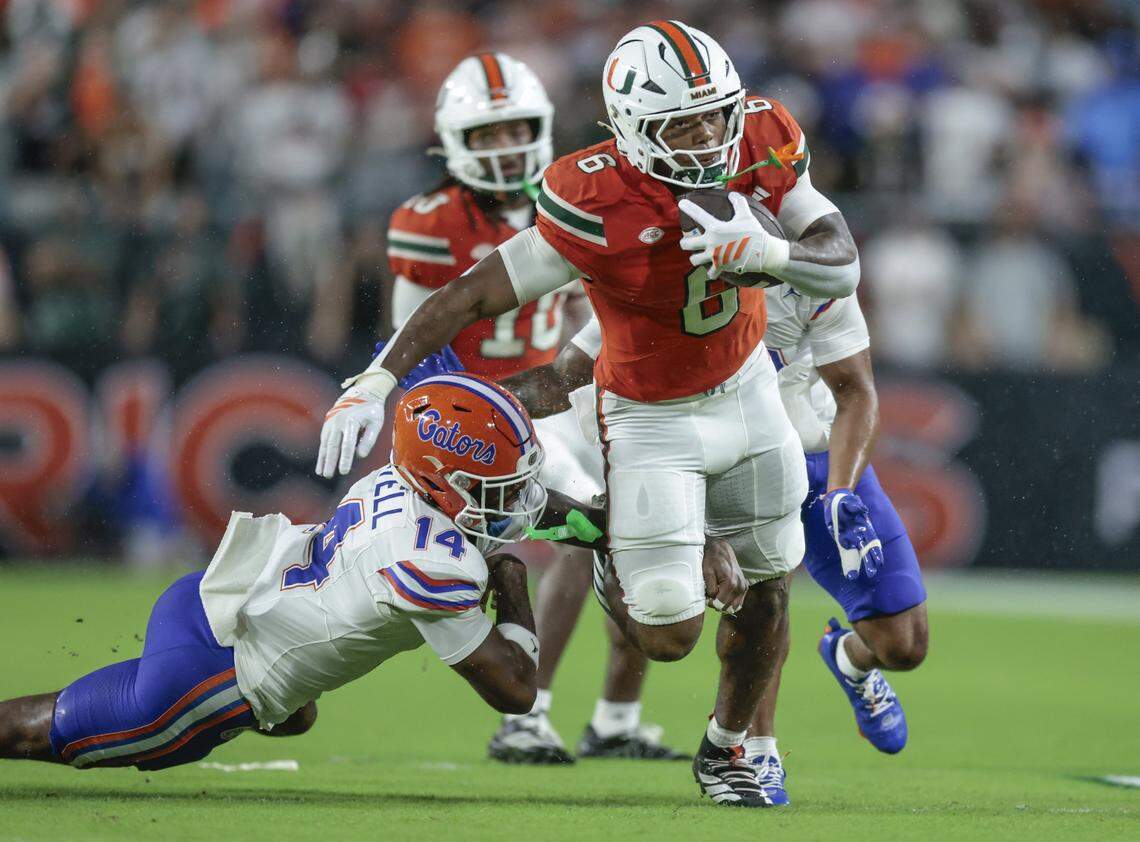 Miami Hurricanes running back CharMar Brown (6) on a carry as Florida Gators defensive back Jordan Castell (14) attempts to make the stop in the first half during their NCAA football game at Hard Rock Stadium in Miami Gardens, Florida, on Saturday, September 20, 2025.