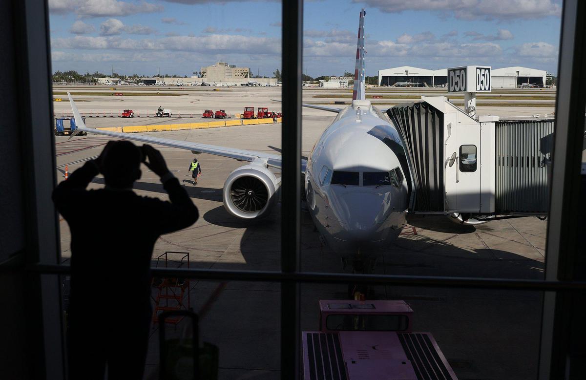 American Airlines’ Flight 718, a Boeing 737 Max, is seen parked at its gate at Miami International Airport as passengers board for the flight to New York on Dec. 29, 2020, in Miami, Florida.