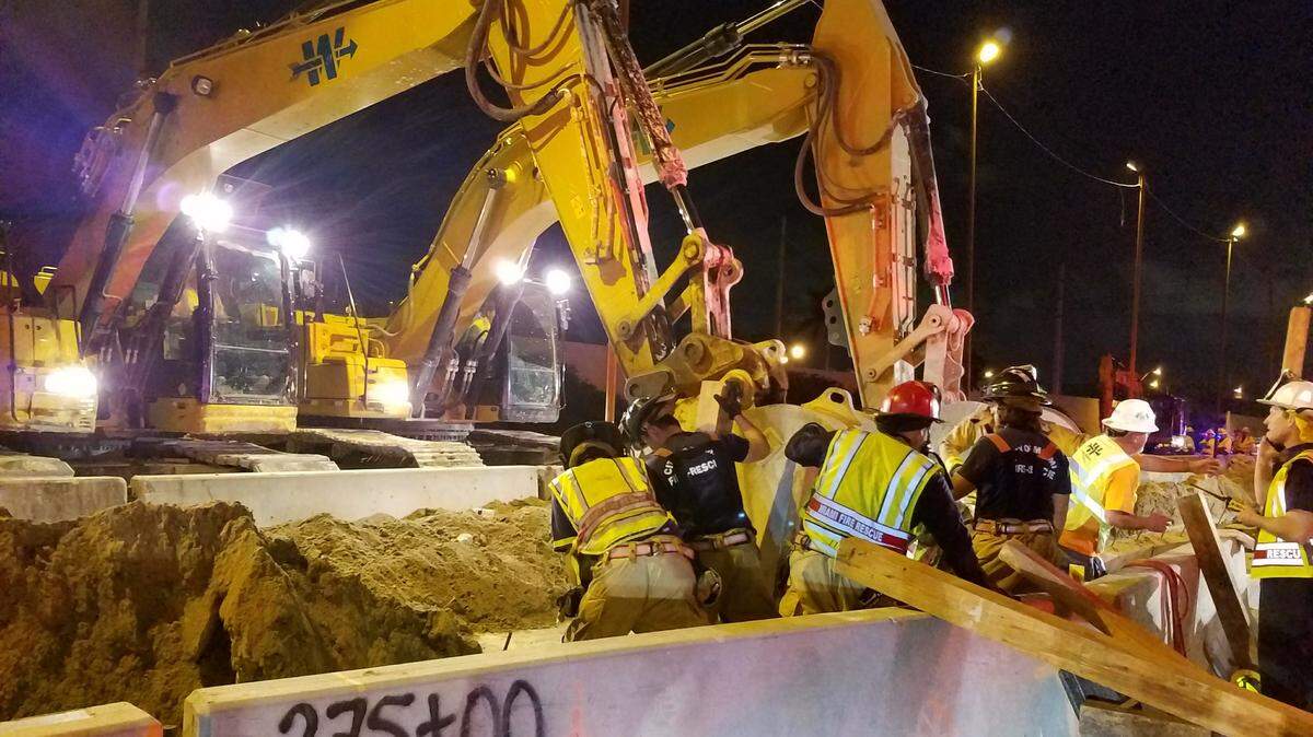 Miami Fire Rescue workers try to get to Abel Orlando Zuniga-Fajardo and Osman Aldubin Montalvan-Ardon after a concrete barrier fell on them Feb. 4.