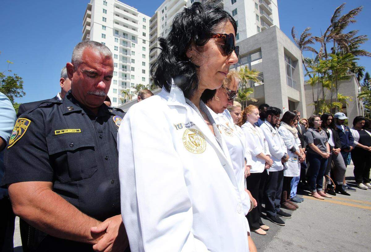 A line of mourners participate in a solemn ceremony at Sweetwater Tower, days after the deadly collapse of the bridge linking the city to Florida International University’s main campus. The tower was built to house members of FIU’s staff and student body.