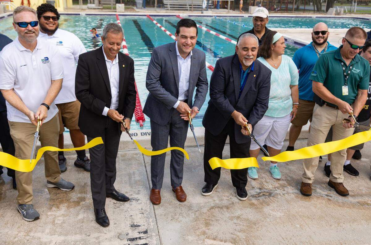 Middle, left to right: Miami-Dade Parks Deputy Director David Cardenas, County Commissioner Kevin Marino Cabrera, and County Chief Operations Officer Jimmy Morales cut the ribbon during the reopening of the A.D. Barnes Pool on Thursday, Aug. 10, 2023 in Miami, Fla.