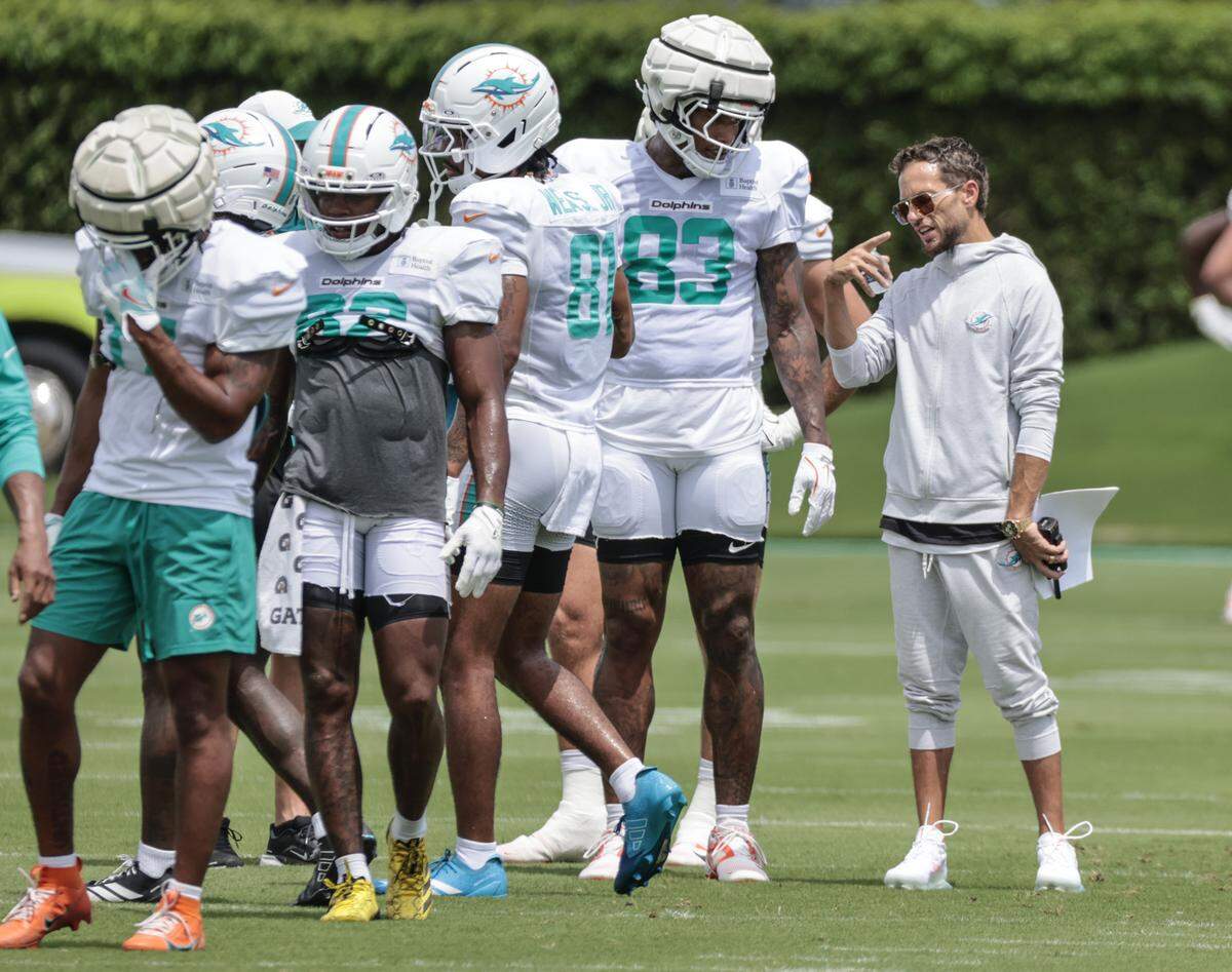 Miami Dolphins head coach Mike McDaniel speaks with tight end Darren Waller (83) during practice at the Miami Dolphins Training Camp in Miami Gardens, Florida, on Wednesday, August 27, 2025.
