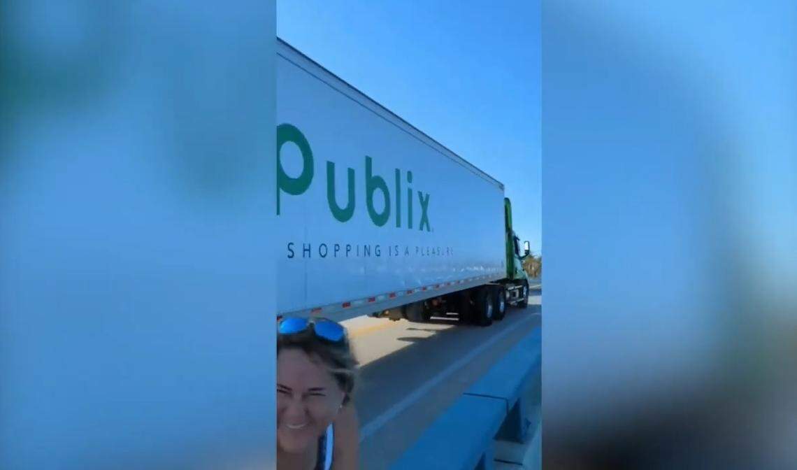In a still from a video posted to a closed Facebook group by Brandon Lynaugh, a Pine Island resident cheers and chuckles as a Publix truck follows a police officer on a new, temporary bridge built by the Florida Department of Transportation to provide access to the Southwest Florida community that was isolated by damage from Hurricane Ian’s landfall on Sept. 28, 2022.