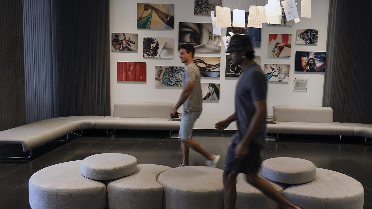 Vecinos atraviesan el vestíbulo del nuevo edificio de condos Canvas, en el distrito Omni de Miami. Los urbanizadores han propuesto un nuevo proyecto subsidiado junto al Canvas que tendría 252 apartamentos para personas de ingresos bajos y medios, en una torre parecida.