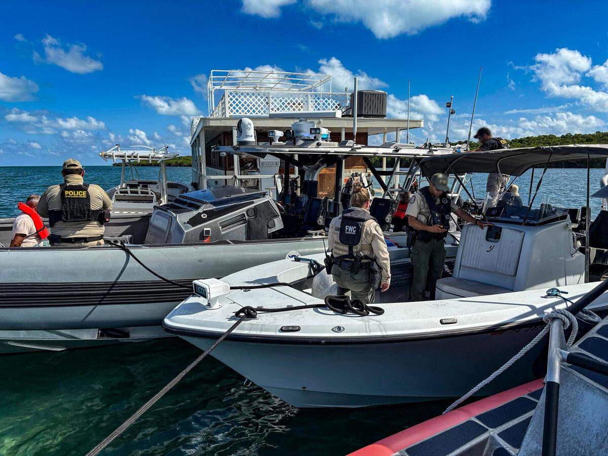 A handcuffed man sits in a U.S. Customs Air and Marine Operations boat off Rodriguez Key Tuesday, Nov. 25, 2025.