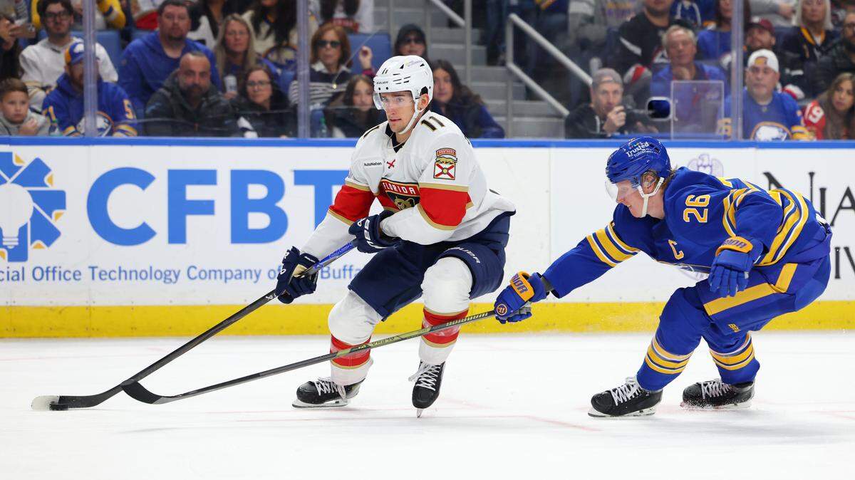 Oct 18, 2025; Buffalo, New York, USA; Florida Panthers right wing Mackie Samoskevich (11) looks to take a shot on goal as Buffalo Sabres defenseman Rasmus Dahlin (26) defends during the first period at KeyBank Center.