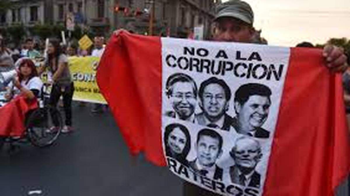 A protester in Lima, Peru, carries a banner with images of past presidents accused of corruption.