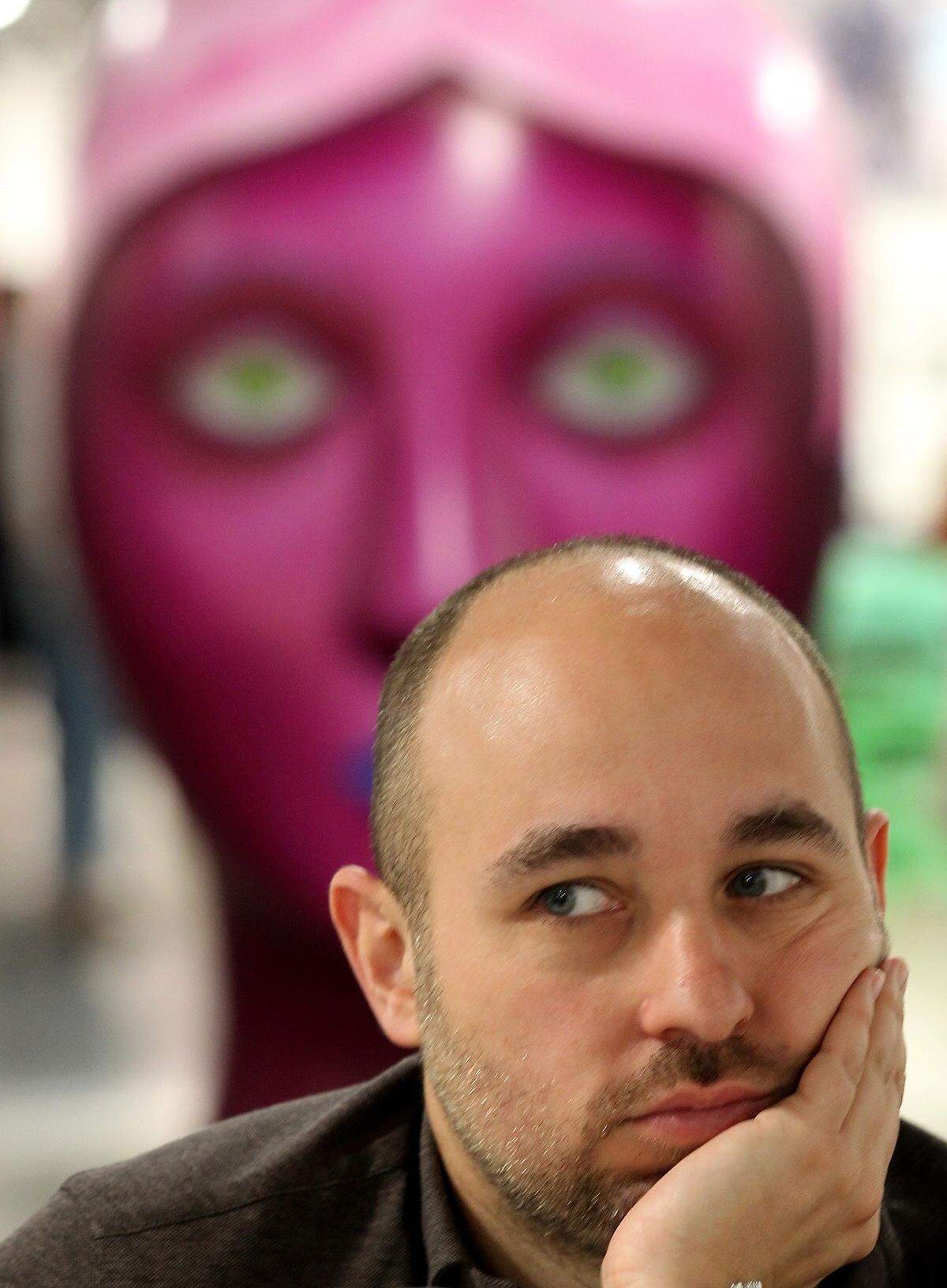 Raphael Oberhuber scopes out the scene while “Head” by Nicolas Party looks on during Day 1 of the annual Art Basel Fair at the Miami Beach Convention Center on Wednesday, Dec. 5, 2018.